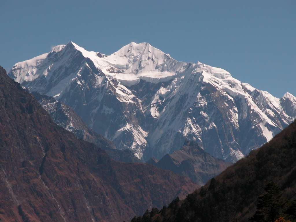 Manaslu 07 09 Shringi Himal From Kharka Near Pung-gyen Gompa From the kharka on the way from Syala to Pung-gyen Gompa, I had a perfect view of the Shringi Himal (7187m). Shringi, also known as Chamar, is an ice sheathed mountain near the Tibetan border. Shringi was climbed for the first time on June 5, 1953 by Maurice Bishop and Nyamgal Sherpa on a four person New Zealand Expedition led by Athol Roberts. Shringi South to the right is only 4m lower at 7183m.